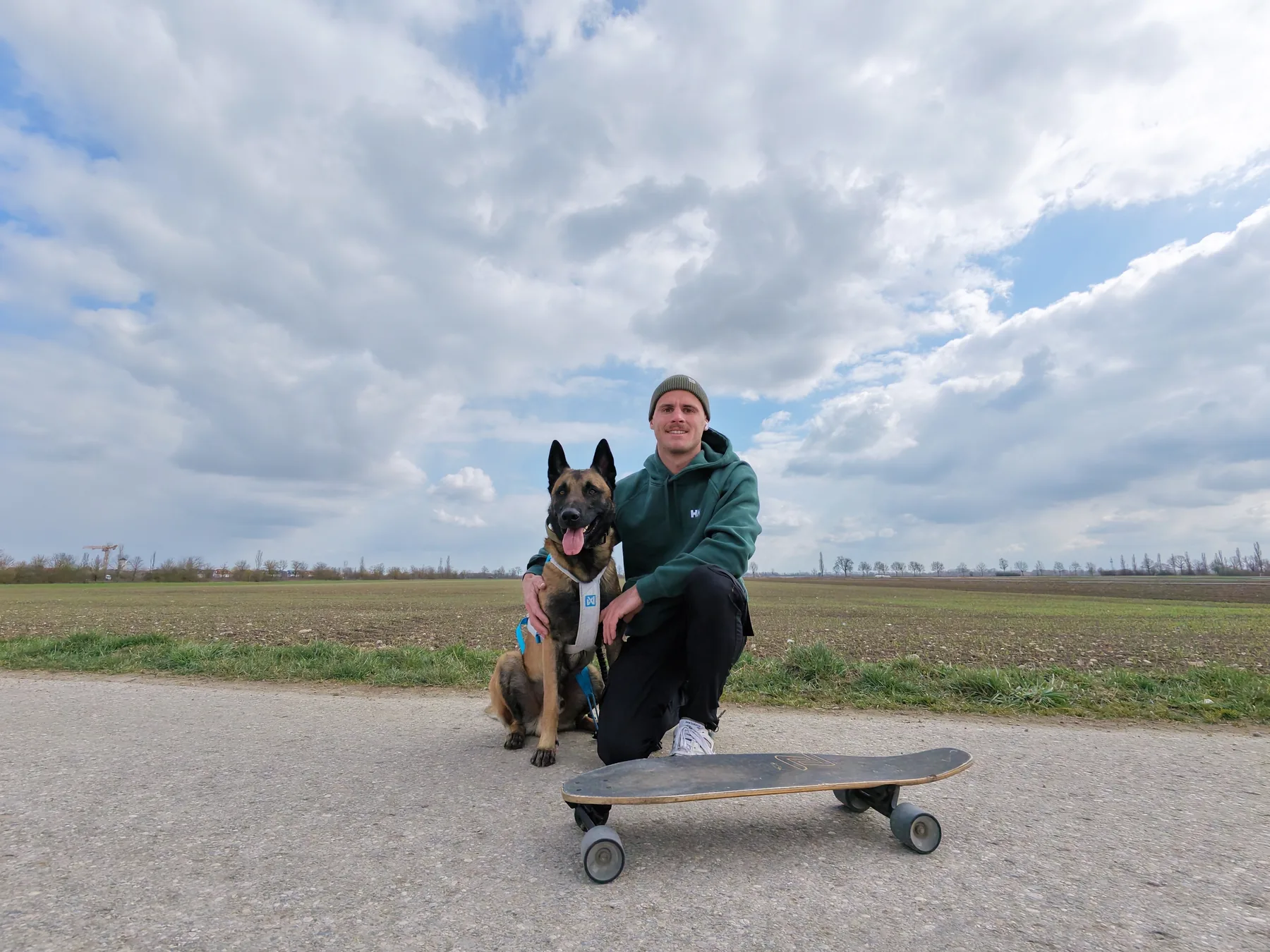 Florian sitzt mit Jake auf einem Feldweg